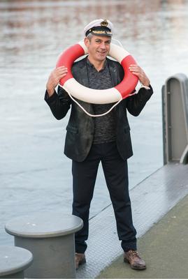 Wladmir Kaminer mit Kapitänsmütze und Rettungsring, Foto: Michael Ihle , zu Buchpromotion "Die Kreuzfahrer"
